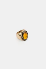 Pack de tres anillos metálicos en tono dorado envejecido, cada uno con una piedra central de forma ovalada en colores amarillo, gris y rosa, con detalles labrados y texturizados en el metal.
