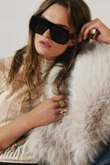 Blusa de manga larga color crema, con cuello alto y detalles de encaje y bordados florales. Presenta paneles verticales con entredoses y un tejido semitransparente.