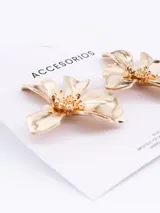 Caravanas con diseño de flor de cuatro pétalos en color dorado con acabado brillante.