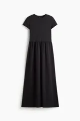 Vestido maxi negro con cuerpo entallado de punto interlock, escote redondo, mangas cortas, costura fruncida en la cintura y falda larga con volumen.