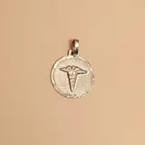 Dije redondo de plata 925 con el símbolo de la medicina en relieve.