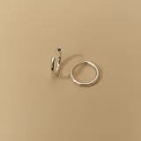 Par de aros tipo argolla de plata 925, de tamaño mediano y forma tubular.