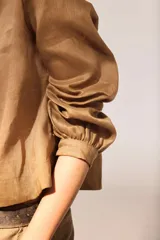 Blusa de lino color marrón con cuello mao, escote en V y mangas largas.