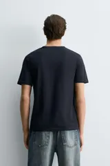 Camiseta de corte ajustado confeccionada en tejido de algodón con elasticidad, cuello redondo y manga corta.