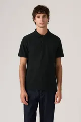 Chomba de piqué color negro con cuello clásico, cierre frontal de dos botones y logo de la marca bordado en el pecho.