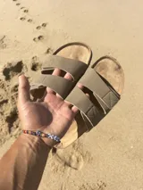 Sandalias planas color beige con doble tira ancha con ajuste de velcro.