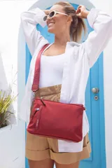 Bandolera morral color rojo, con cierre principal, bolsillo frontal horizontal y bolsillo dorsal. Incluye correa de galón a tono con la marca "Lincoln's" grabada.