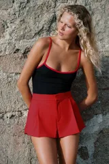 Shorts de tiro medio con bolsillos laterales y detalle de pinzas delanteras. Cierre frontal con cremallera, botón interior y gancho metálico.