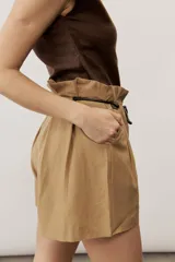 Short blanco de tiro alto, confeccionado en lino, con bolsillos laterales y cordón ajustable en la cintura.