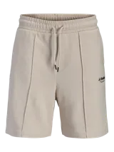 Bermuda deportiva beige de calce relajado, con costuras frontales en relieve y pequeño estampado lateral.