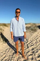 Camisa celeste con rayas verticales blancas, de lino, manga larga y corte clásico.