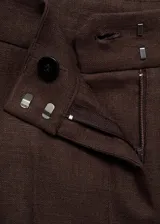 Pantalon de vestir de corte recto, confeccionado en lino con forro interior de algodón. Presenta cierre oculto de botón, gancho y cremallera, con elástico en la parte posterior de la cintura y bolsillos laterales.