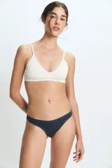 Bombacha tipo colaless de color negro con estampado de pequeños puntos blancos, confeccionada en poliamida y elastano con forro de algodón.
