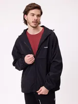 Campera rompevientos negra con capucha ajustable, cierre frontal completo y puños elásticos. Presenta logo de la marca estampado en el pecho.