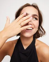 Anillo abierto bañado en oro amarillo 18k con un topacio blanco engarzado en un extremo y una barra vertical en el otro.