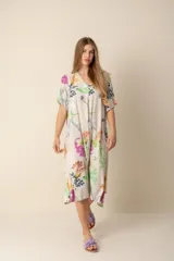 Vestido largo estampado con flores en tonos violeta, naranja, verde y azul sobre un fondo beige claro. Tiene cuello en V y mangas cortas.