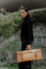 Buzo de punto color blanco con cuello alto y detalles de pespuntes decorativos en color negro en las costuras de los hombros, puños y ruedo.