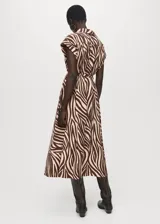 Vestido midi de corte recto con estampado animal print tipo cebra en tonos marrón y beige. Presenta cuello camisero, cierre frontal con botones, mangas cortas con vuelta y cinturón tipo batín para ajustar a la cintura.