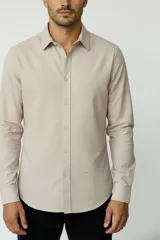Camisa de poliéster color marrón, de corte holgado, con mangas largas, cuello camisero clásico y cierre frontal de botones.