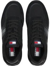 Zapatillas Tommy Jeans de corte bajo, color negro, con exterior de ante y detalles distintivos de la marca.