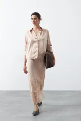 Falda midi negra de caída fluida con cintura elastizada y un amplio detalle de encaje negro en el bajo.