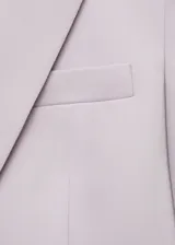 Chaqueta entallada de diseño recto con cuello de solapa con muesca, cierre frontal de un botón, hombros estructurados y mangas largas con puños abotonados. Cuenta con dos bolsillos de ribete en la parte delantera y uno en el pecho, además de una abertura posterior y forro interior.