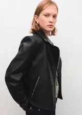 Chaqueta estilo biker de cuero sintético negro, con cierre frontal cruzado, solapas con muesca y broches metálicos.