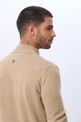 Campera tejida de lana color azul marino, con cuello alto, cierre metálico frontal y bolsillos laterales. Presenta detalles en cuero y logo bordado.