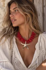 Collar corto de cuentas de coral rojo con un gran dije colgante en forma de estrella de mar.
