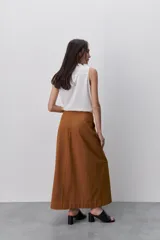 Falda larga color tostado, de línea evasé y silueta amplia, con diseño de paneles y costuras visibles pespunteadas.