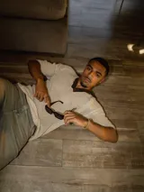 Chomba de tejido de punto abierto color crudo con cuello polo en color marrón chocolate.