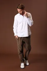 Camisa blanca de manga larga con cuello clásico y cierre frontal con botones.