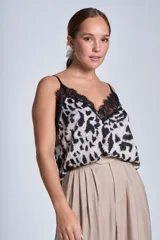 Musculosa con estampado animal print en tonos beige y negro, con escote en V y detalle de encaje negro en el escote.
