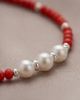 Collar de cuentas rojas con diseño central de tres perlas blancas separadas por pequeñas piezas de plata 925.