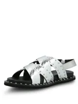 Sandalias de cuero plateado con textura de reptil, diseño de tiras cruzadas decoradas con tachas metálicas. Poseen ajuste mediante hebilla lateral y suela de goma con detalle de tachas en el borde.