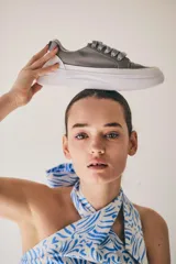 Championes urbanos de color gris con suela de plataforma blanca y cordones al tono.