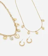 Set de accesorios compuesto por dos collares de cadena en capas con dijes de corazón y un par de aros tipo argolla texturizados. Los collares presentan diferentes estilos de eslabones y detalles de cristales incrustados en los dijes.