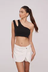 Top corto blanco de algodón, con un solo hombro y corte asimétrico.