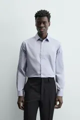 Camisa de algodón de manga larga, color celeste claro, con cuello italiano y cierre frontal de botonadura.