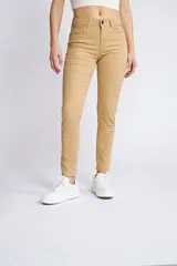 Pantalón de gabardina corte skinny, color beige, con diseño de cinco bolsillos, cierre de cremallera y botón frontal.