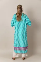 Túnica larga estampada en tonos turquesa, blanco y fucsia, con mangas cortas, calce holgado, tajos laterales y detalle de guarda en el ruedo.