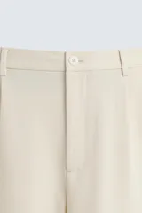 Bermuda de hombre color verde claro, de corte regular y tiro medio, con pinzas frontales, bolsillos laterales y bolsillos traseros de vivo. Cierre frontal con botón y cremallera.