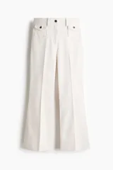 Pantalón de sarga color blanco de corte acampanado y tiro alto, con bolsillos delanteros de parche con solapa y botones oscuros, y pliegues marcados en el centro de las piernas.