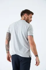 Polo gris con textura diferenciada, fit regular, logo estampado, con cierre y manga corta.
