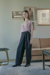 Pantalón de tiro medio, pierna ancha y diseño cruzado en la parte delantera con detalle de lazo y botón lateral.