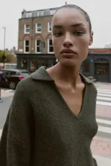 Jersey de punto liso con tacto suave, cuello polo, manga larga y bolsillos delanteros de plastrón.
