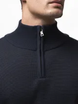 Sweater de tejido de punto con textura tipo waffle, color azul marino, con cuello alto y cierre frontal parcial. Cuenta con puños y ruedo acanalados.