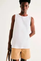 Musculosa blanca de corte clásico y diseño liso, confeccionada con tejido de algodón suave y fresco, ideal para uso diario.