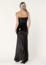 Vestido largo de fiesta con escote strapless. La parte superior presenta un diseño ajustado cubierto de lentejuelas negras, mientras que la parte inferior está confeccionada en chiffon plisado con paneles godet que aportan volumen y movimiento.