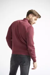 Campera tejida de algodón en color bordó, con cierre frontal completo, cuello levemente elevado y textura acanalada. Presenta puños y ruedo elásticos.